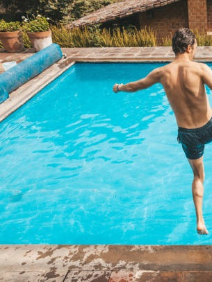 photo gauche d'un papa et son fils qui sautent dans une piscine